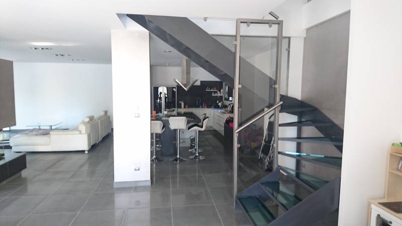 Vu d'un escalier en acier avec marches en verre dans une maison au Mont d'Or près de Lyon
